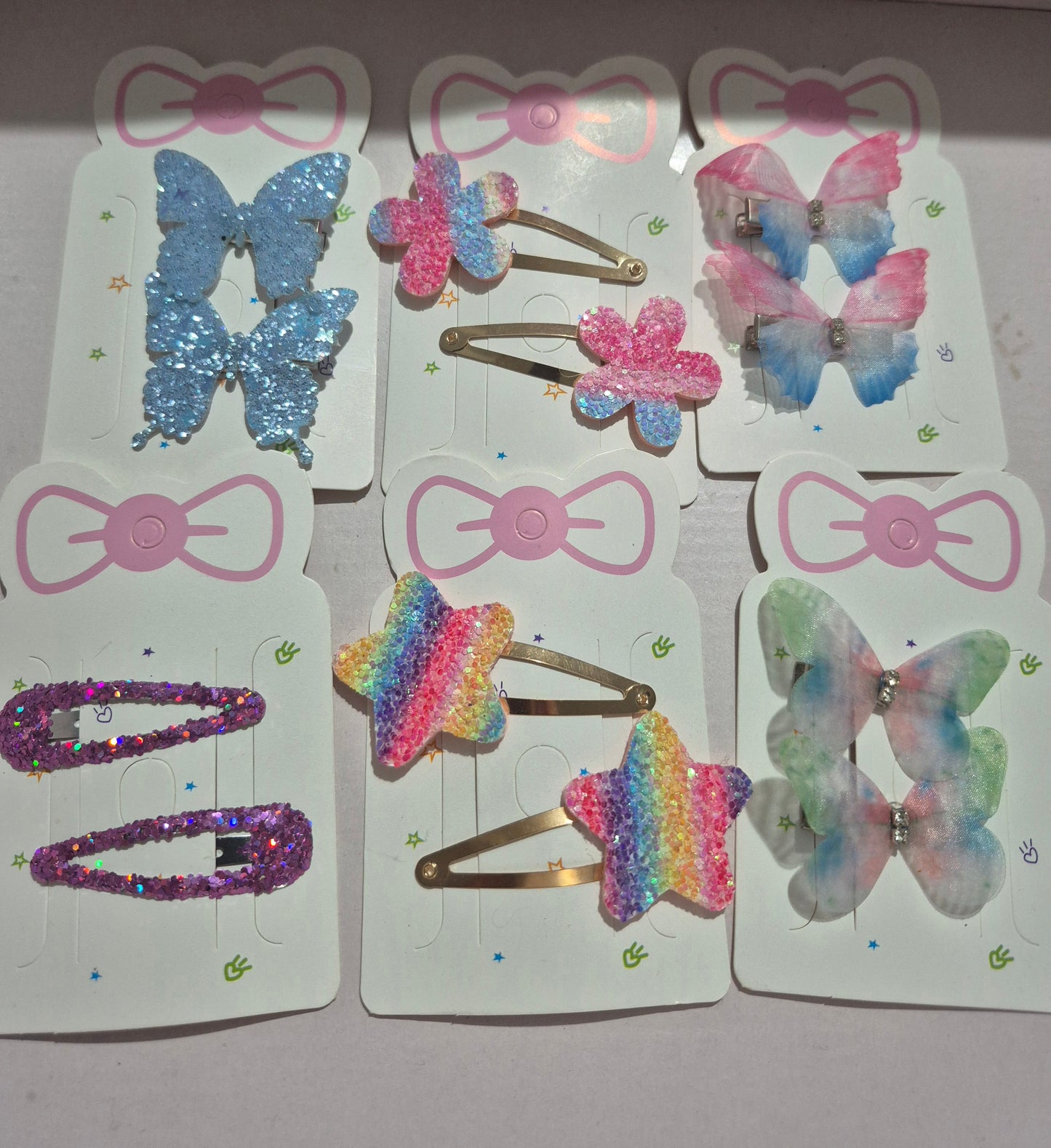 Colorful butterfly-shaped hair clips on display cards with decorative bows.