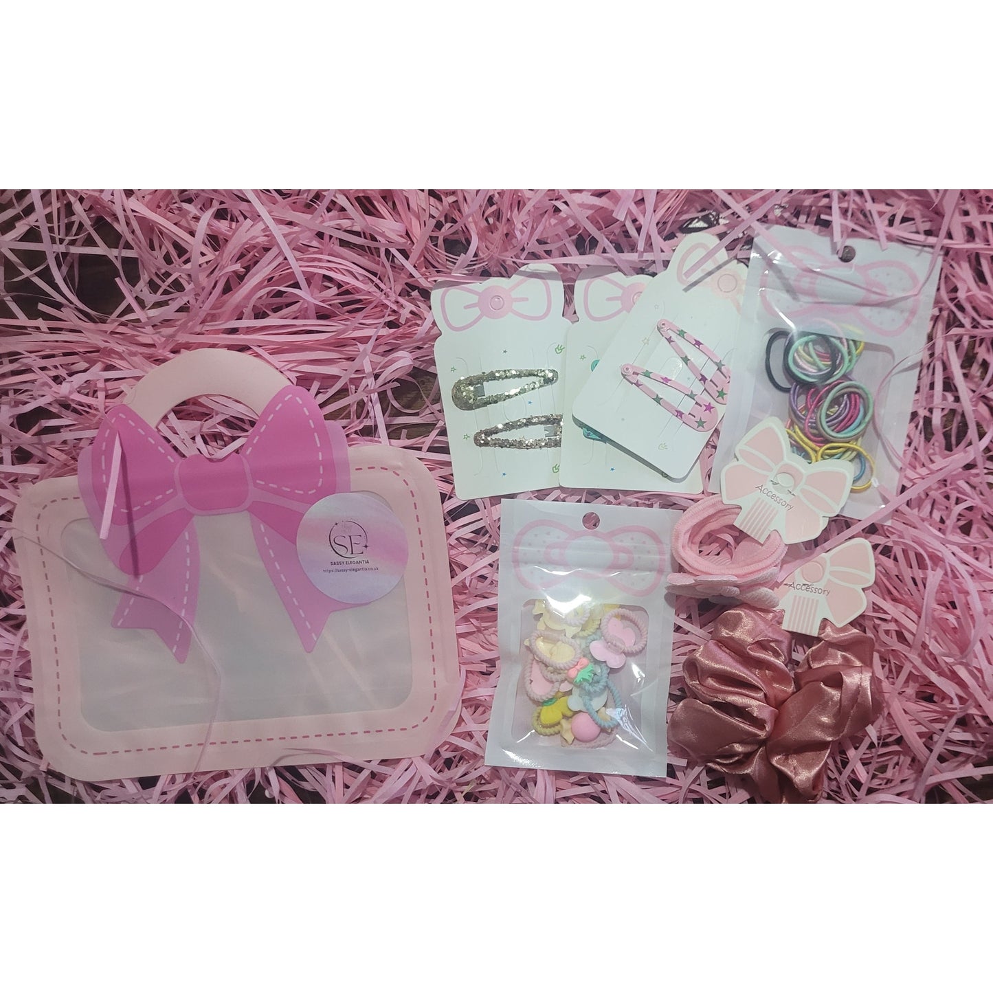 Collection of hair accessories including bows and clips on a pink textured background