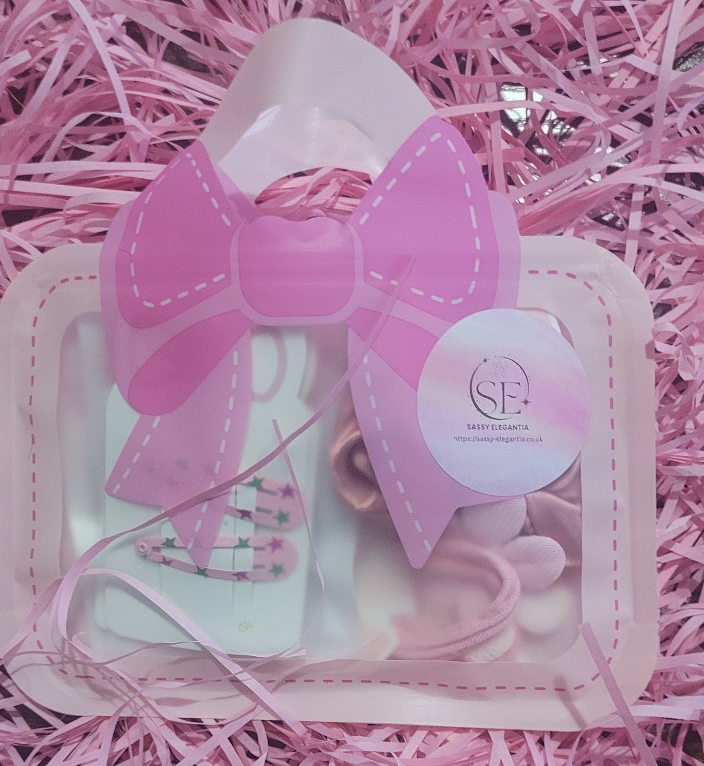 Pink hair bow and accessories set on a pink background