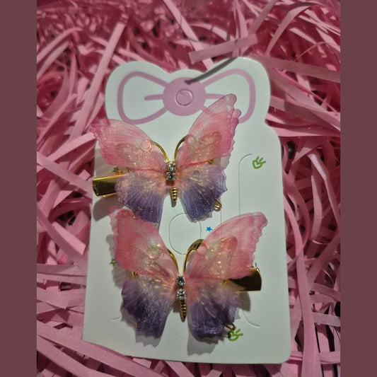 Butterfly-shaped earrings on a pink card with pink shredded paper background