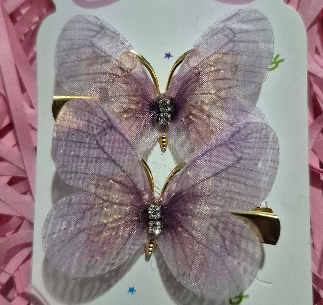 Butterfly-shaped hair clips on a card with pink decorative paper underneath