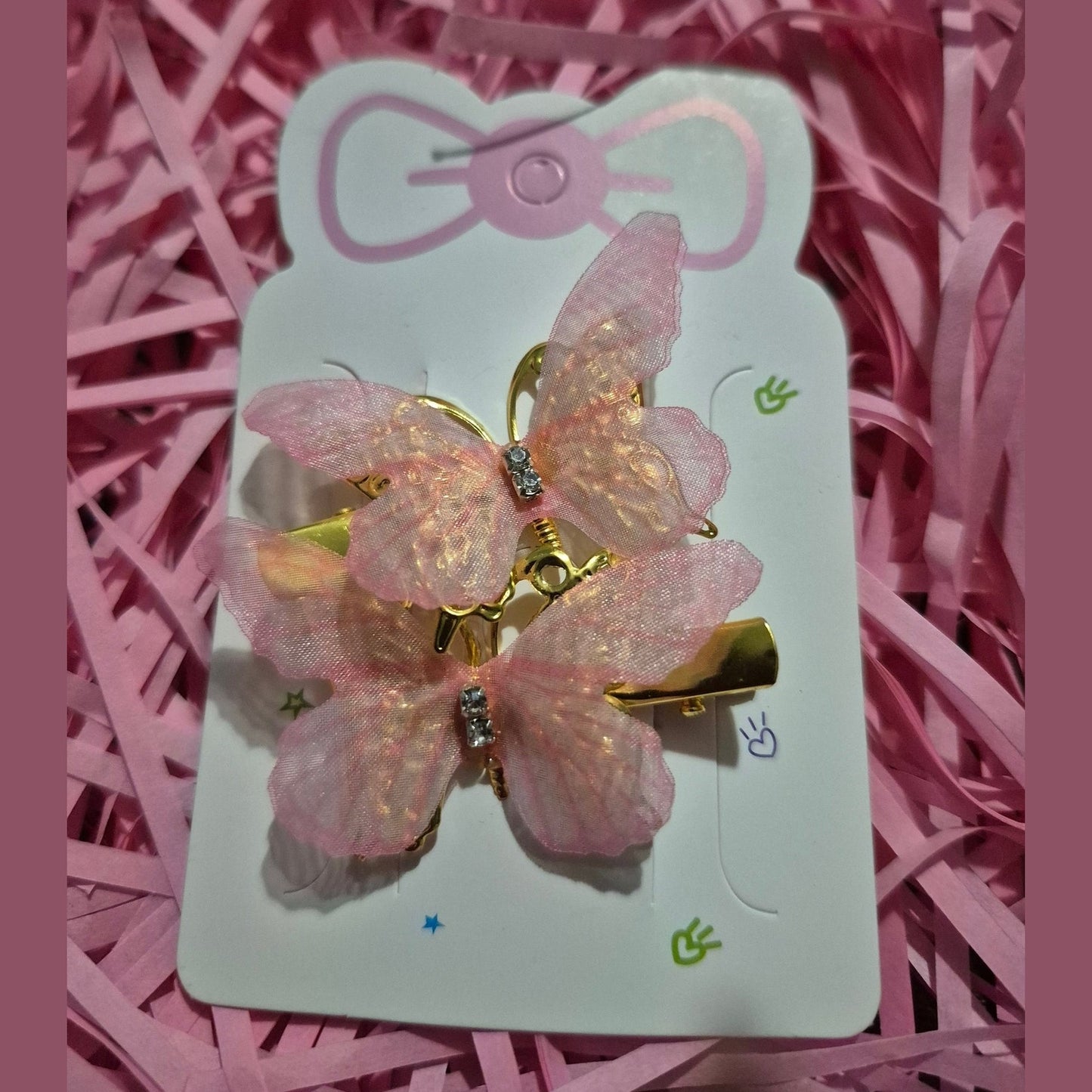 Pink butterfly hair clip on a card with pink background