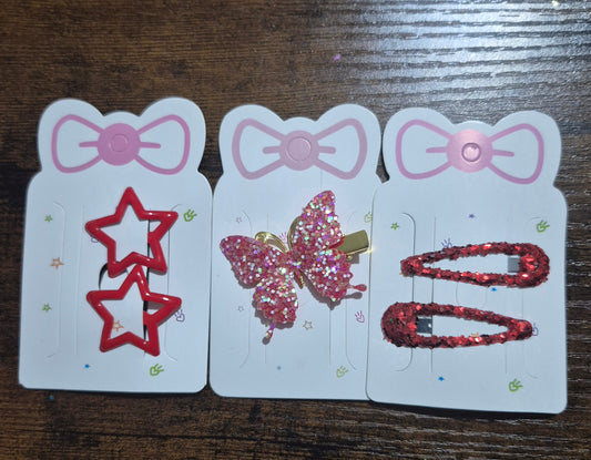 Three hair clip cards with different hair clips on a wooden surface