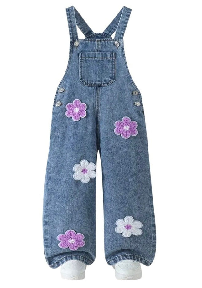 Denim overalls with floral patches on a white background